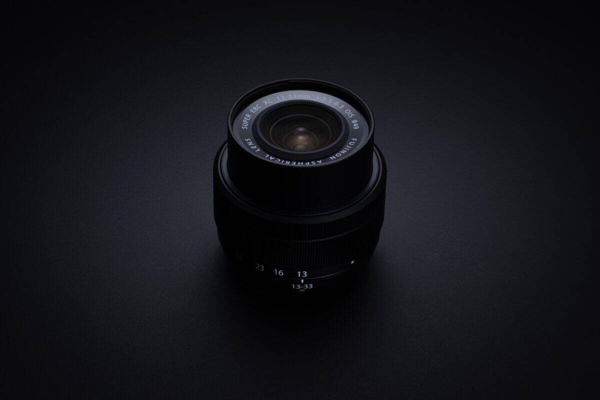 Fujifilm XC 13-33mm OIS Objektiv auf schwarzem Hintergrund.
